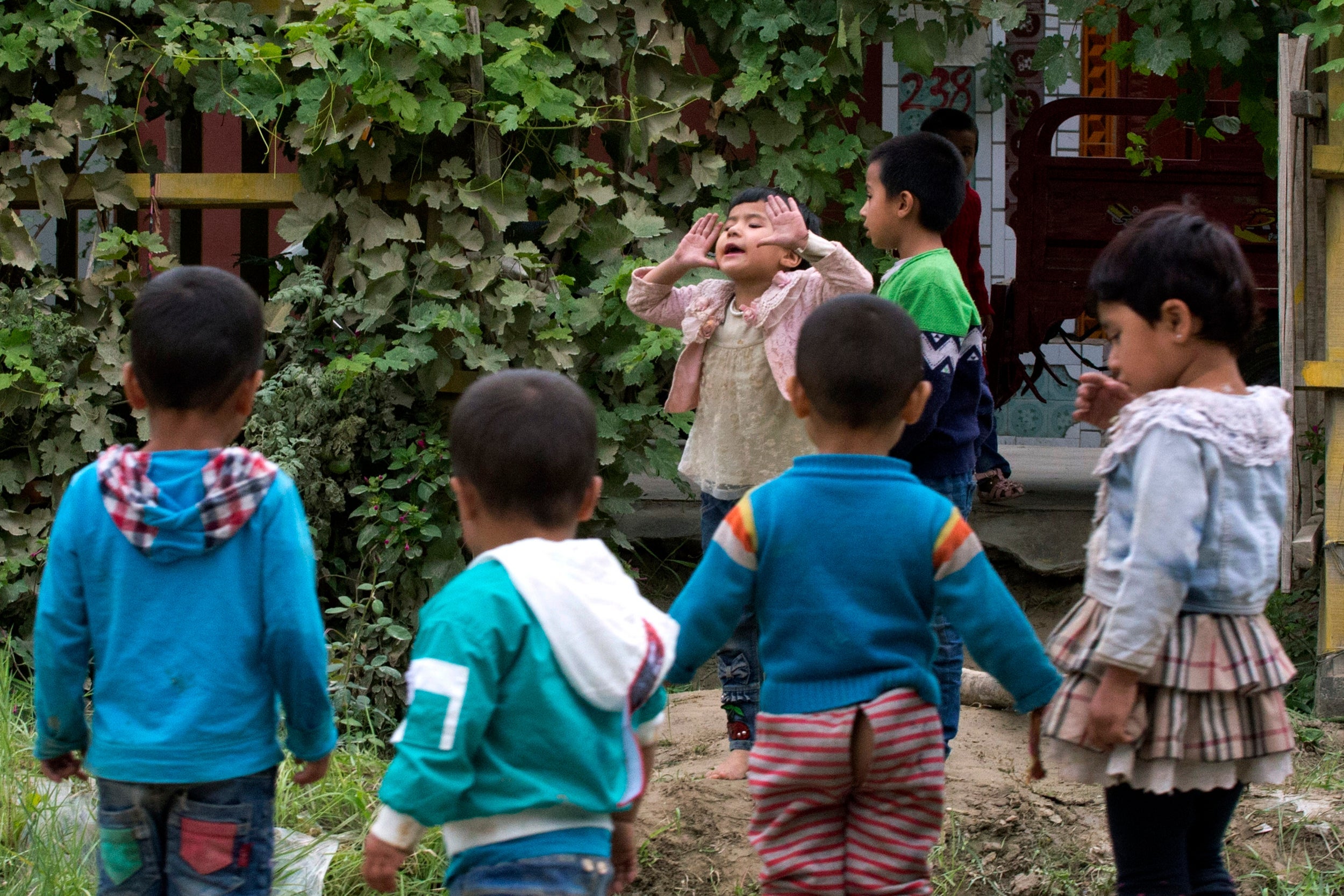 Uighur children play outdoors in Hotan, in western China's Xinjiang region