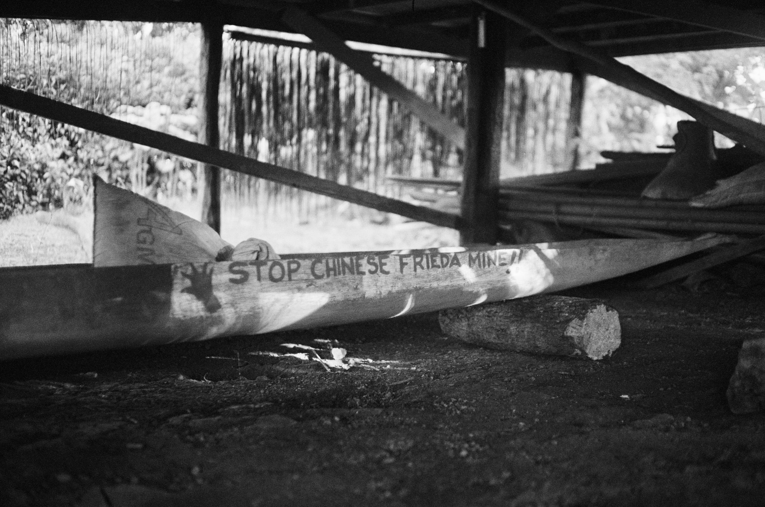 Stop Chinese Freida Mine is hand-painted along an abandoned canoe. Manu has yet to meet a Sepik villager who supports the mine