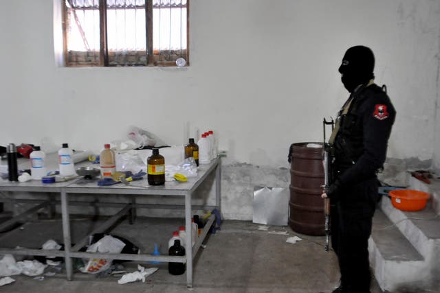An Albanian police officer searches a clandestine cocaine refining laboratory in the village of Xibrake, near Elbasan, on January 15, 2015. Around 100 kilograms of elaborated cocaine and 18.8 kilograms of pure cocaine were found in the laborator