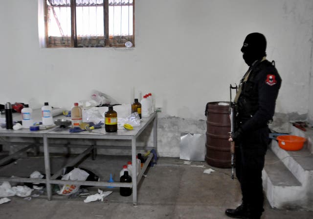 An Albanian police officer searches a clandestine cocaine refining laboratory in the village of Xibrake, near Elbasan, on January 15, 2015. Around 100 kilograms of elaborated cocaine and 18.8 kilograms of pure cocaine were found in the laborator