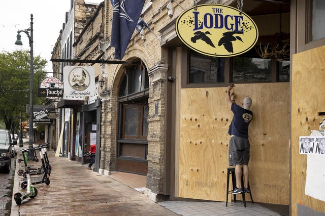 General manager of The Lodge, boards up his bar on East 6th Street in Austin, Texas