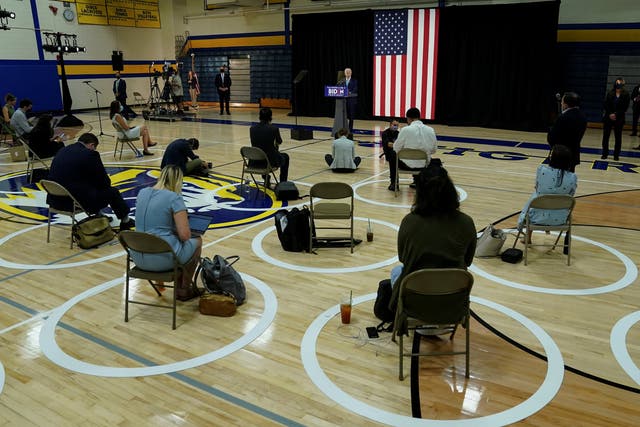 Joe Biden conducts a press conference with reporters socially distanced in a school gym