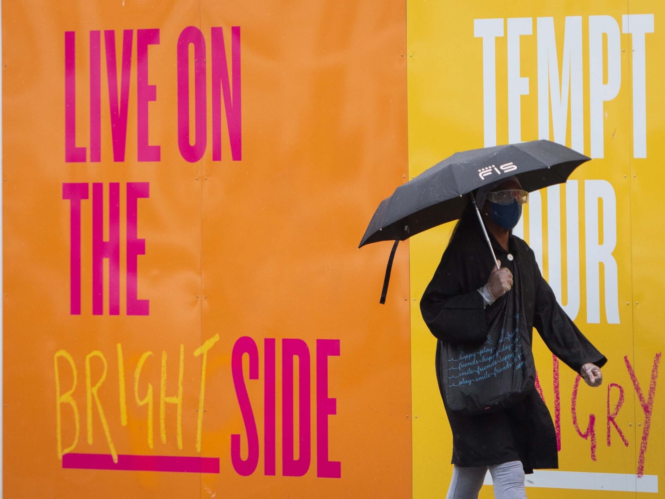 A woman shelters under an umbrella in central London, as rain, wind and weather warnings are bringing an end to the sweltering June heatwave