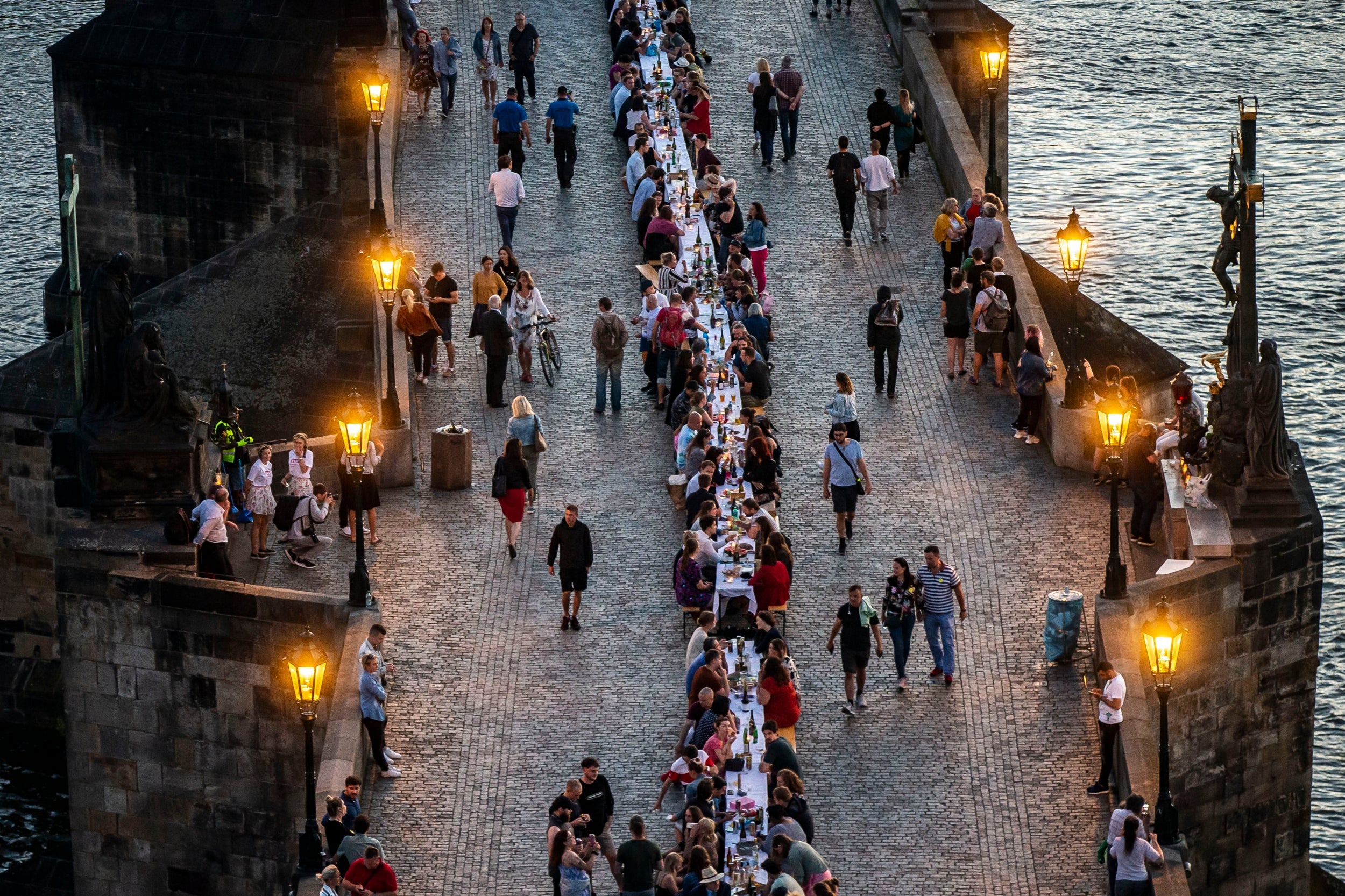 Residents sit to dine on a 500 meter long table set on the Charles Bridge