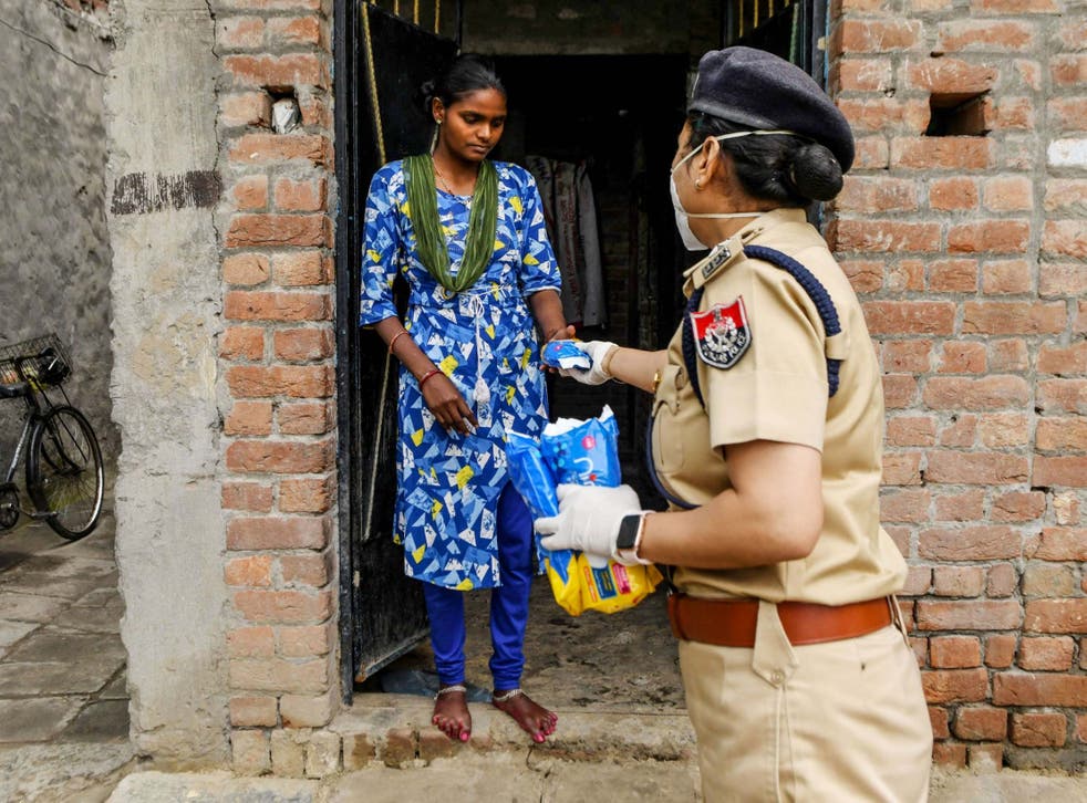 A Punjab police official distributes sanitary pads to residents in lockdown