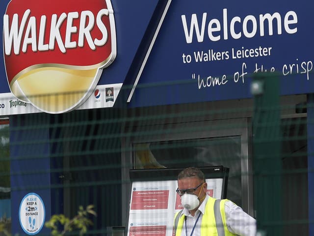 A man exits the Walkers Crisps factory that has confirmed cases of coronavirus amongst its workers in Leicester