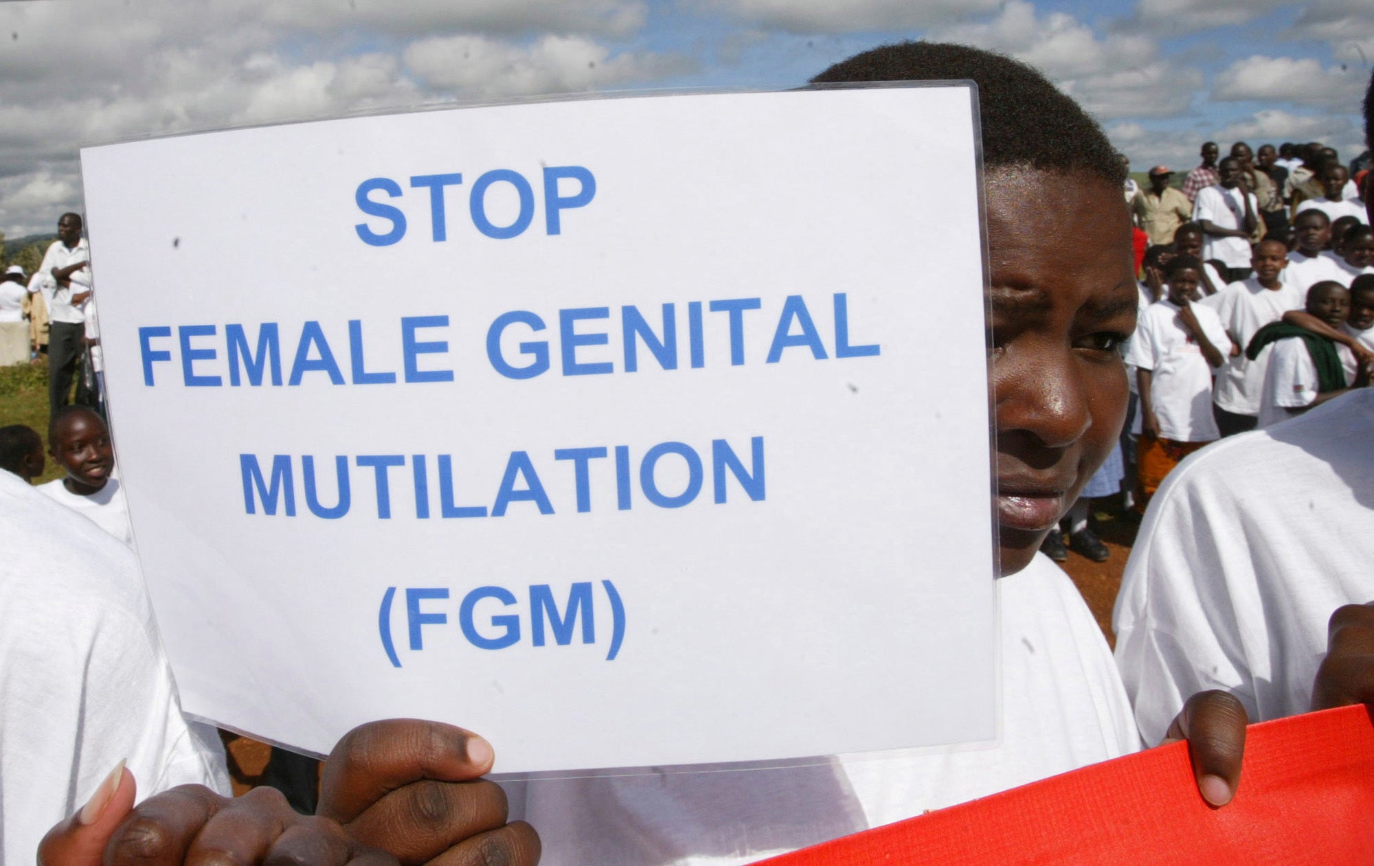 In this 2007 photo, a Masai girl holds a protest sign during the anti-FGM protest in Kilgoris, Kenya. Nearly always carried out on minors, it can result in excessive bleeding and death or cause problems including infections, complications in childbirth and depression