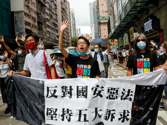 Pan-democratic legislator Eddie Chu Hoi-dick, Vice convener for Hong Kong's Civil Human Rights Front Figo Chan, and activist Leung Kwok-hung, also known as "Long Hair", march at the anniversary of Hong Kong's handover to China from Britain, in Hong Kong on 1 July 2020.