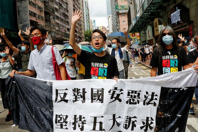 Pan-democratic legislator Eddie Chu Hoi-dick, Vice convener for Hong Kong's Civil Human Rights Front Figo Chan, and activist Leung Kwok-hung, also known as "Long Hair", march at the anniversary of Hong Kong's handover to China from Britain, in Hong Kong on 1 July 2020.