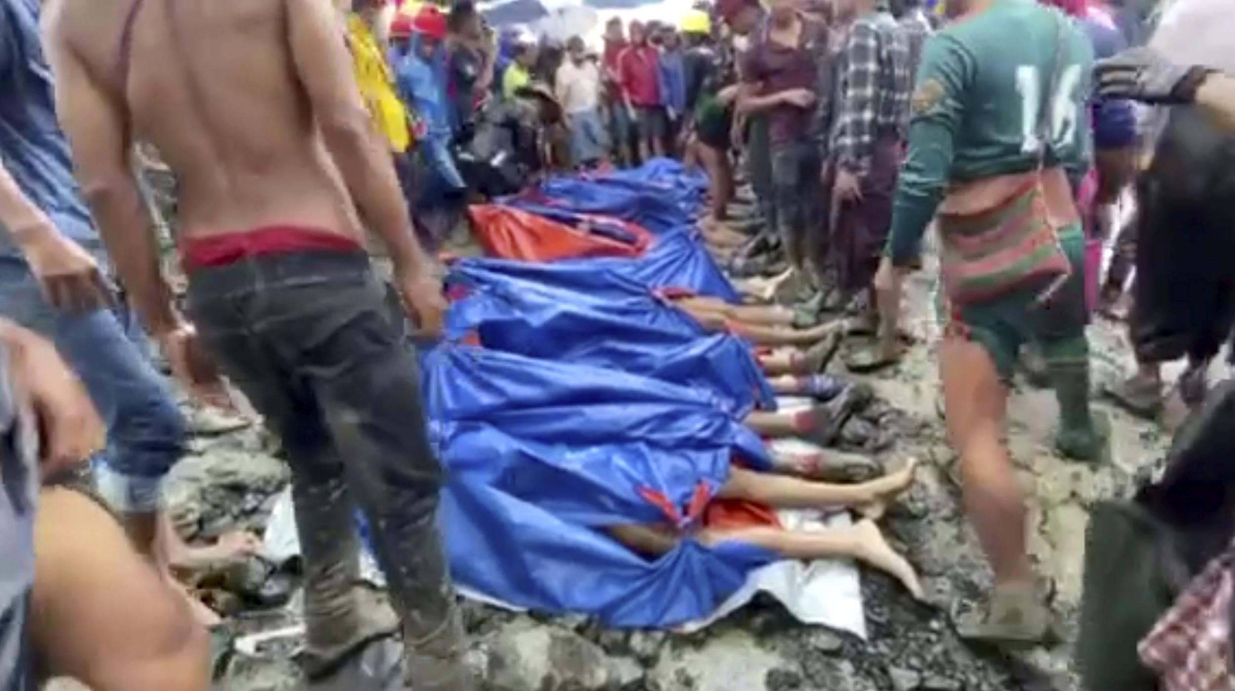 People gather near the bodies of victims