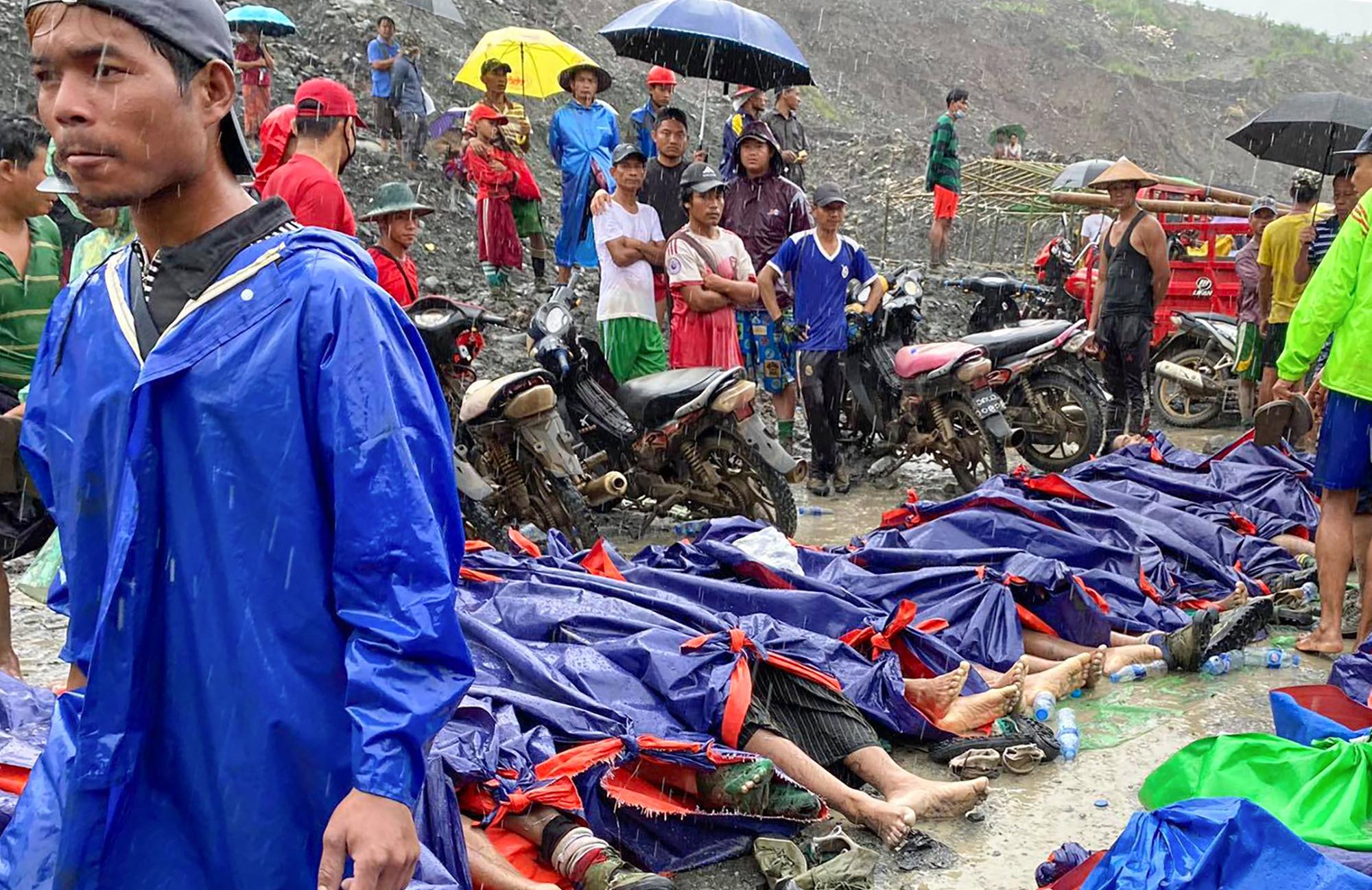 People gather near the bodies of victims in the jade mining area of Hpakant, Kachin state, northern Myanmar