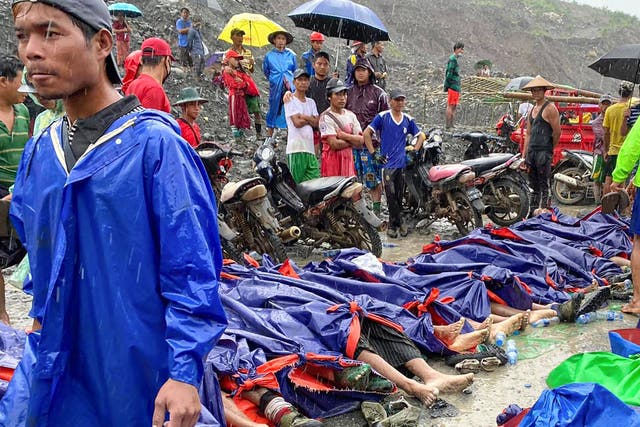 People gather near the bodies of victims in the jade mining area of Hpakant, Kachin state, northern Myanmar
