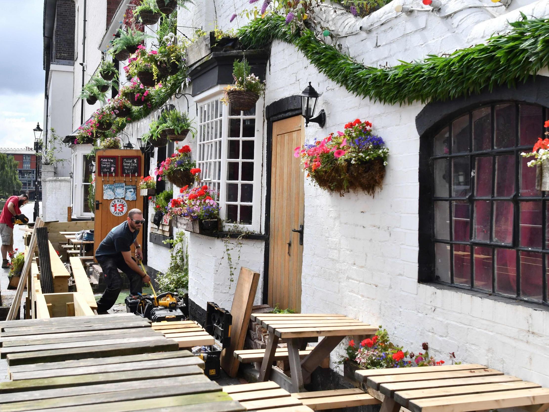 Workers prepare an outdoor seating area at a pub in Birmingham on 2 July, 2020, ahead of "super Saturday".