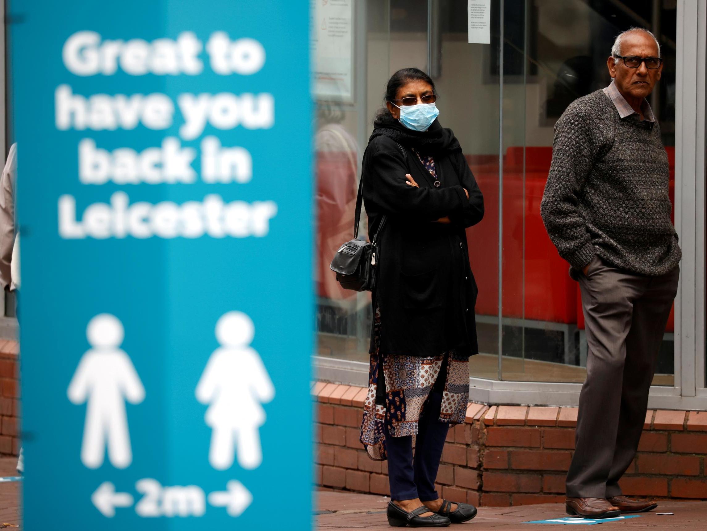 People stand on the street following a local lockdown imposed amid the coronavirus surge in Leicester