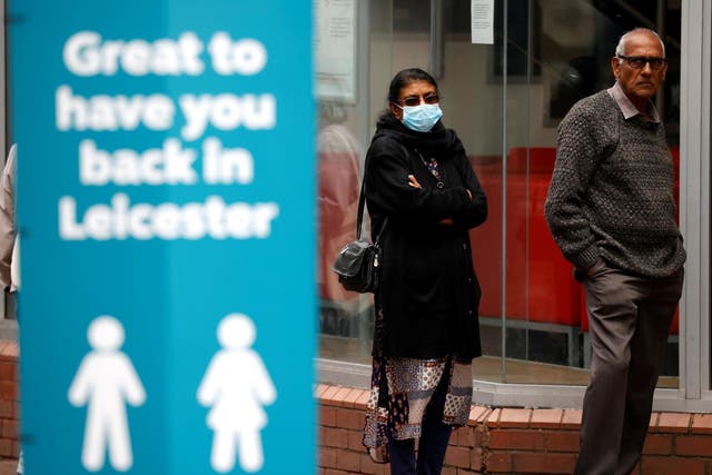 People stand on the street following a local lockdown imposed amid the coronavirus surge in Leicester