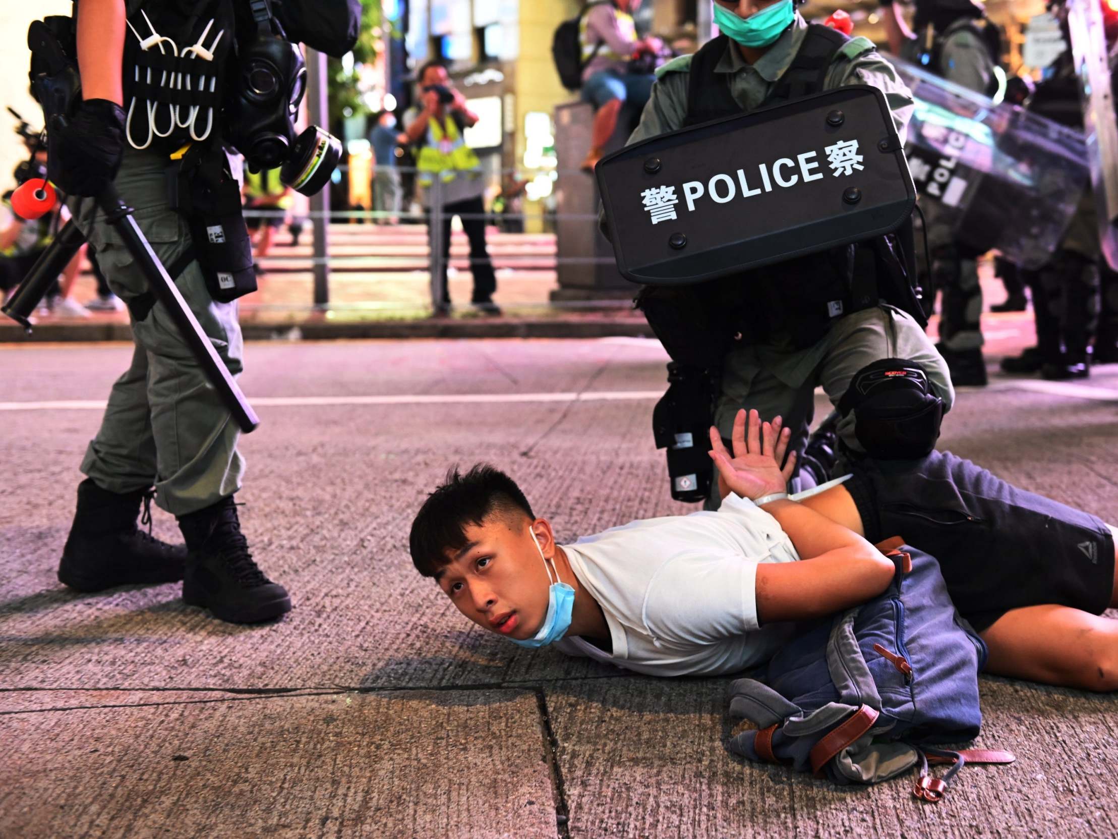 Police officers detain protesters during a rally against a new national security law