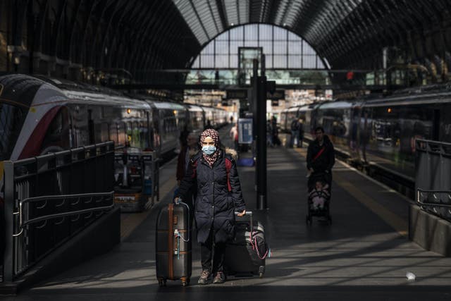 A passenger wears a protective mask at King's Cross train station on March 16, 2020 in London, England