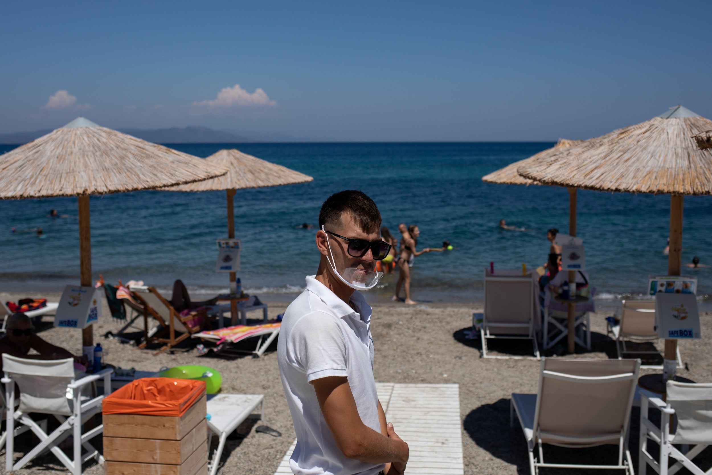 A waiter welcome customers at a beach bar on the island of Kos (Reuters)