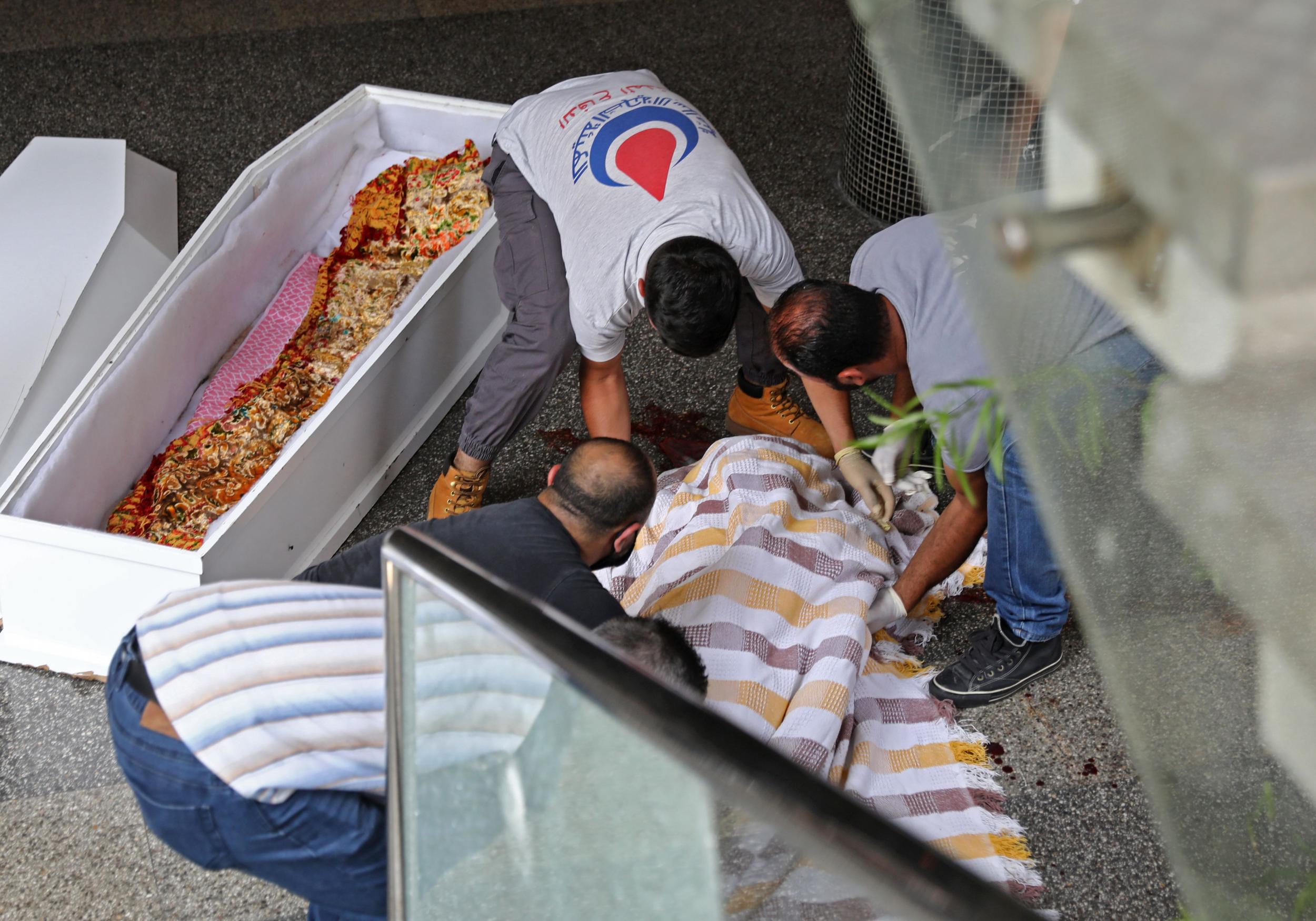 Medics in Beirut place the body of a 61-year-old man into a coffin, after he took his life due to the country’s deepening economic downturn (AFP/Getty)