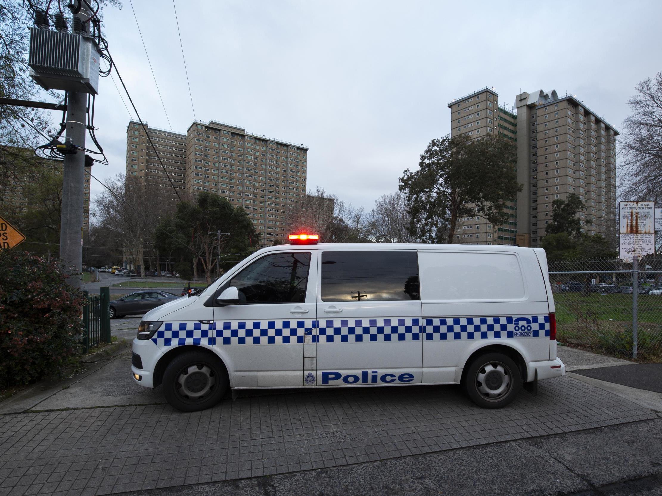 Police patrols are seen outside public housing towers on Racecourse Road in Melbourne