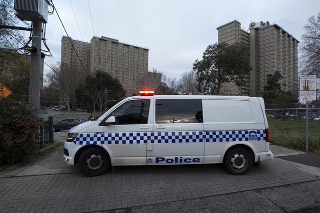 Police patrols are seen outside public housing towers on Racecourse Road in Melbourne