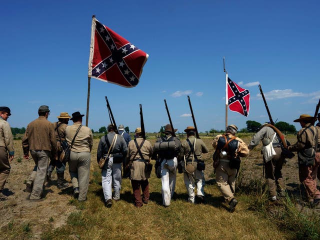 Civil War reenactors march with Confederate flags at Gettysburg, were armed militia met on Saturday
