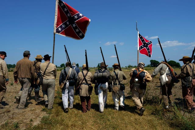 Civil War reenactors march with Confederate flags at Gettysburg, were armed militia met on Saturday