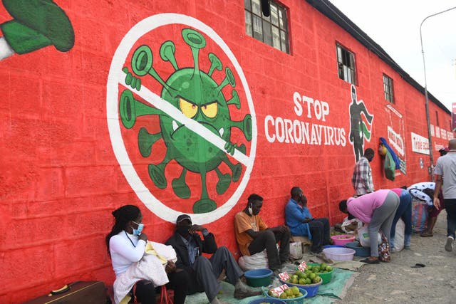 Traders sell their wares below graffiti raising awareness about Covid-19 in Nairobi last month