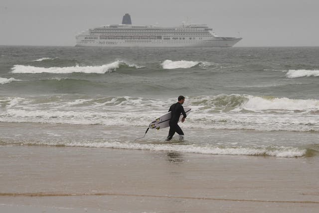 A surfer pictured on Bournemouth beach in grey conditions on Saturday 4 July, 2020.