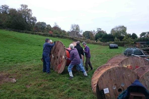 Keep rolling: locals move a reel of plastic across a field
