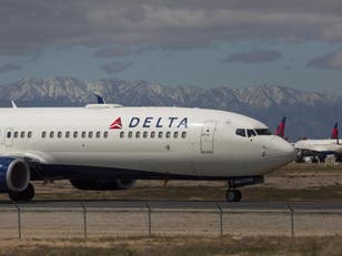 A Delta Air Lines jet taxis to be parked with a growing number of jets at Southern California Logistics Airport