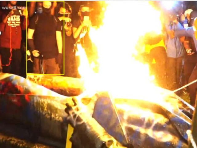 A statue of Albert Pike burns after being toppled by protesters.