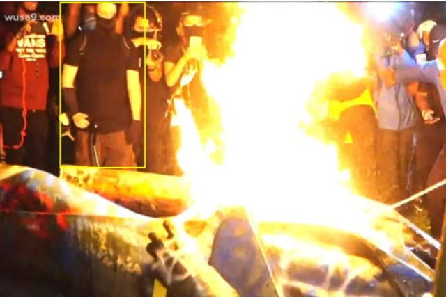 A statue of Albert Pike burns after being toppled by protesters.