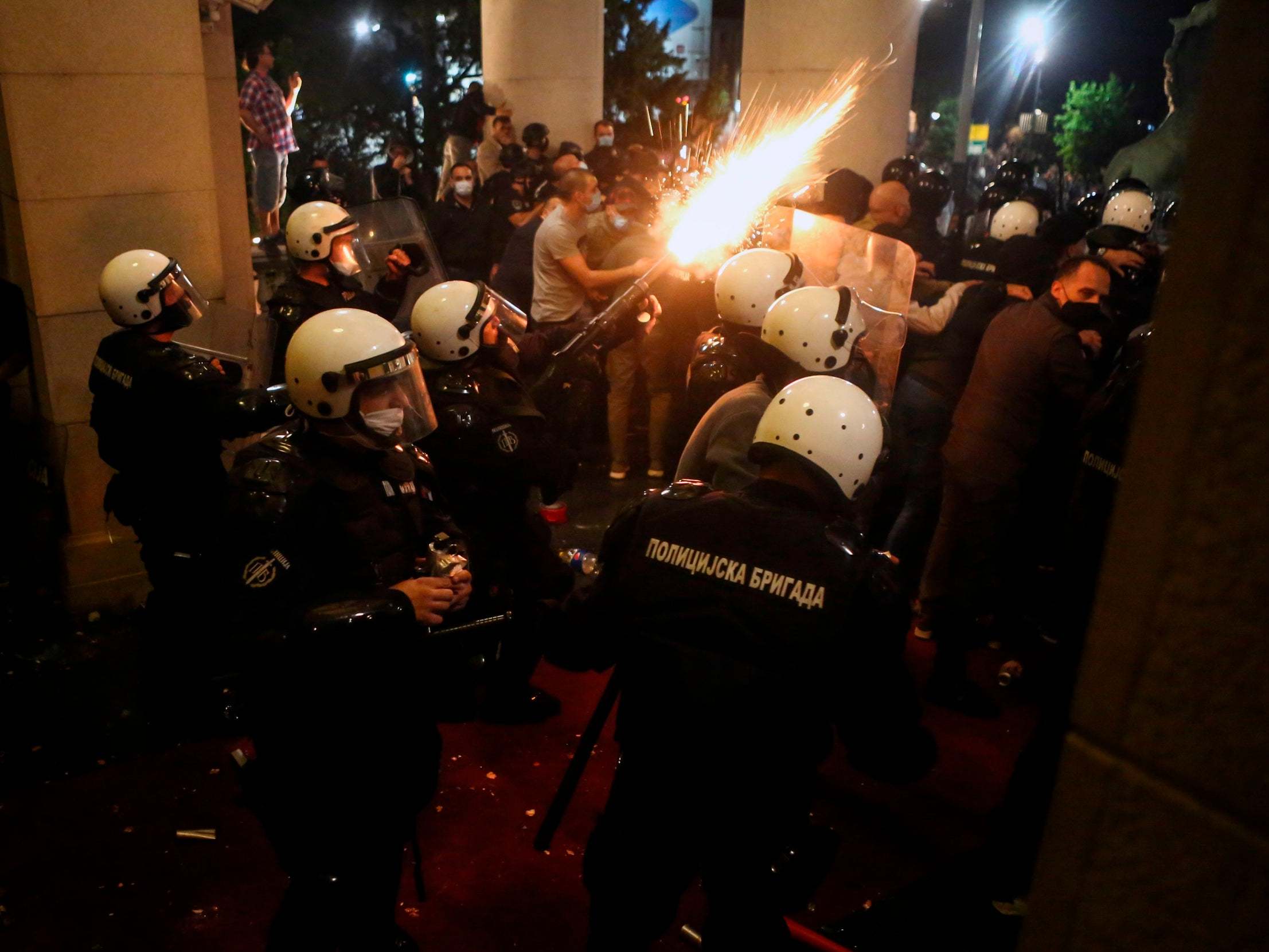 Protesters and police clash in front of the National Assembly building in Belgrade