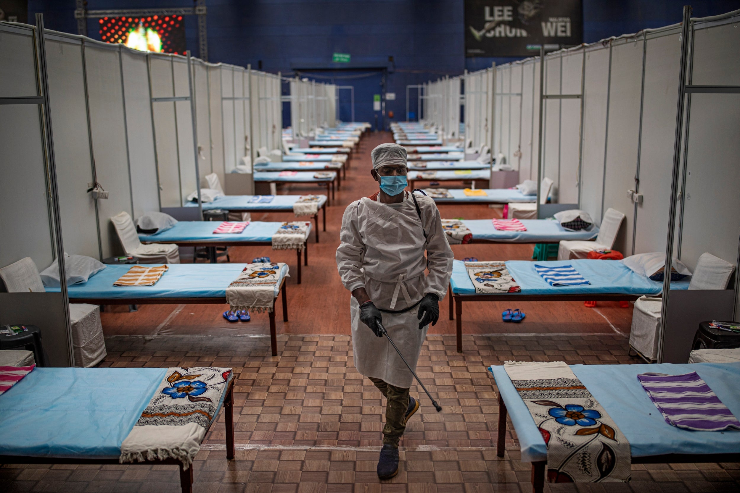 A member of the hospital staff sanitises a makeshift Covid care centre at an indoor sports stadium in New Delhi