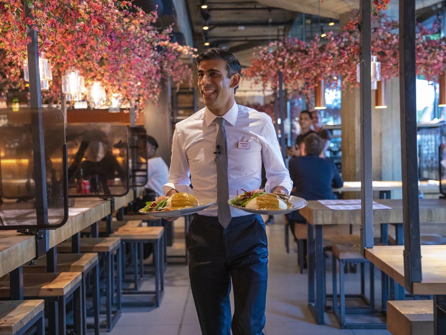 Chancellor Rishi Sunak serves food to customers in Wagamama, after announcing meal discounts for restaurant patrons in a bid to help the industry recover from the coronavirus crisis