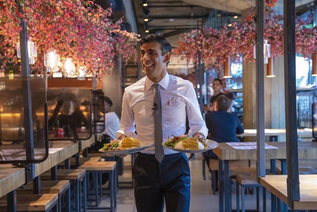 Chancellor Rishi Sunak serves food to customers in Wagamama, after announcing meal discounts for restaurant patrons in a bid to help the industry recover from the coronavirus crisis