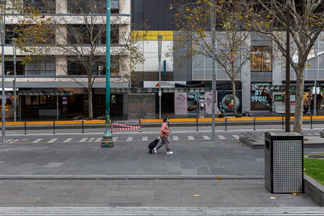 A lone shopper walks along a quiet Swanston Street in Melbourne