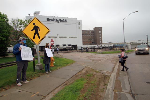 Residents holding thank-you signs to greet employees of a pork processing plant as they returned to their shifts after the plant had been closed because of a coronavirus outbreak in Sioux Falls, South Dakota in May