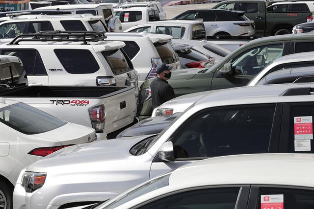 An official with Homeland Security Investigations walks among vehicles worth an estimated $3.2 million, at Port Everglades after they were seized by Homeland Security Investigations, Wednesday, July 8, 2020, in Fort Lauderdale, Fla. 