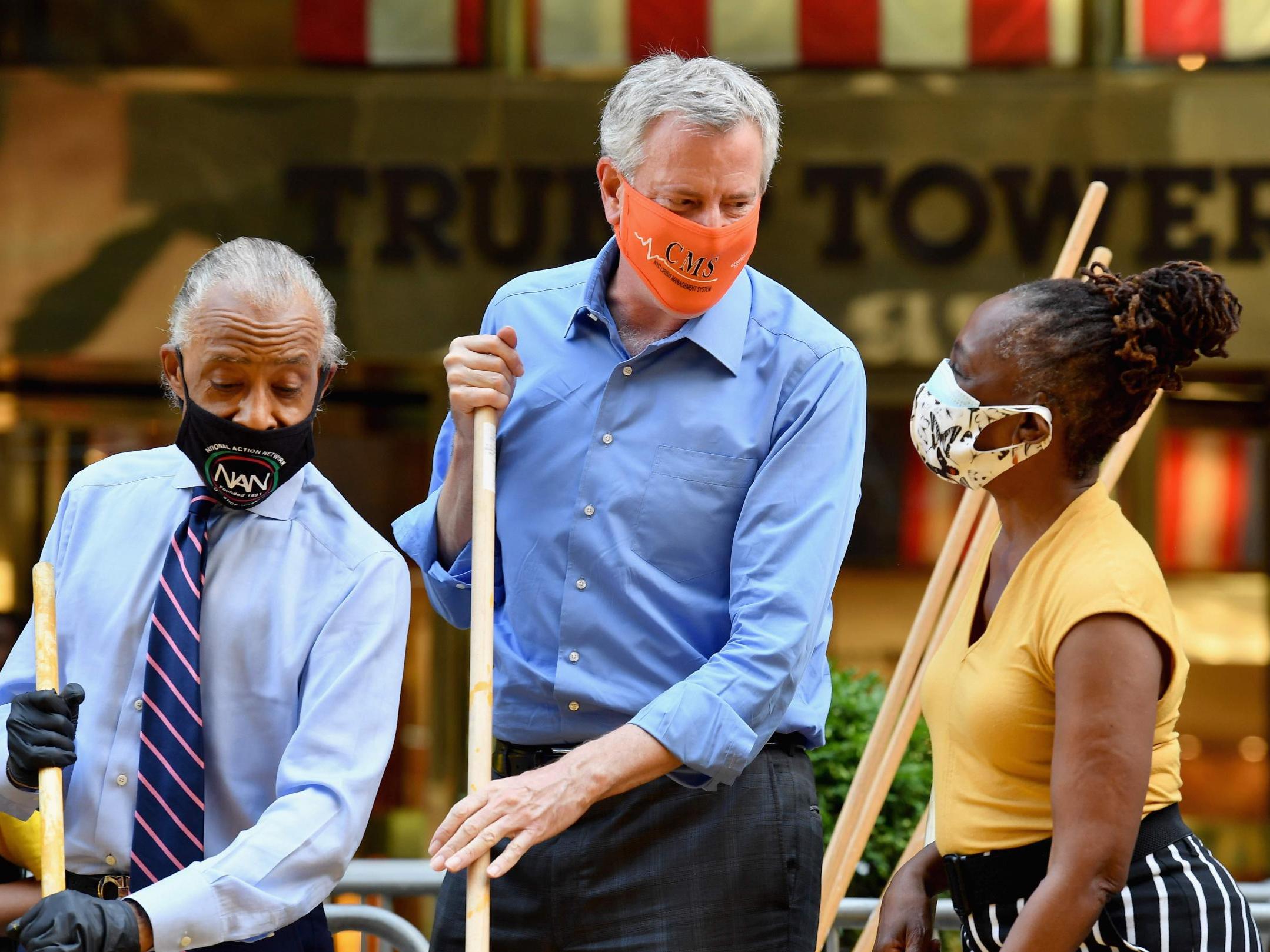 The Reverend Al Sharpton, New York Mayor Bill de Blasio and his wife Chirlane McCray, paint a new Black Lives Matter mural outside of Trump Tower