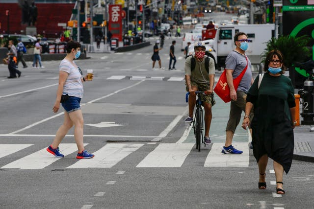 Masked pedestrians walk in Manhattan's Times Square