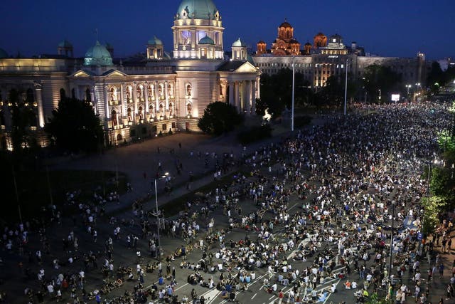 Demonstrators peacefully sit on the street in front of the parliament during a protest in Belgrade