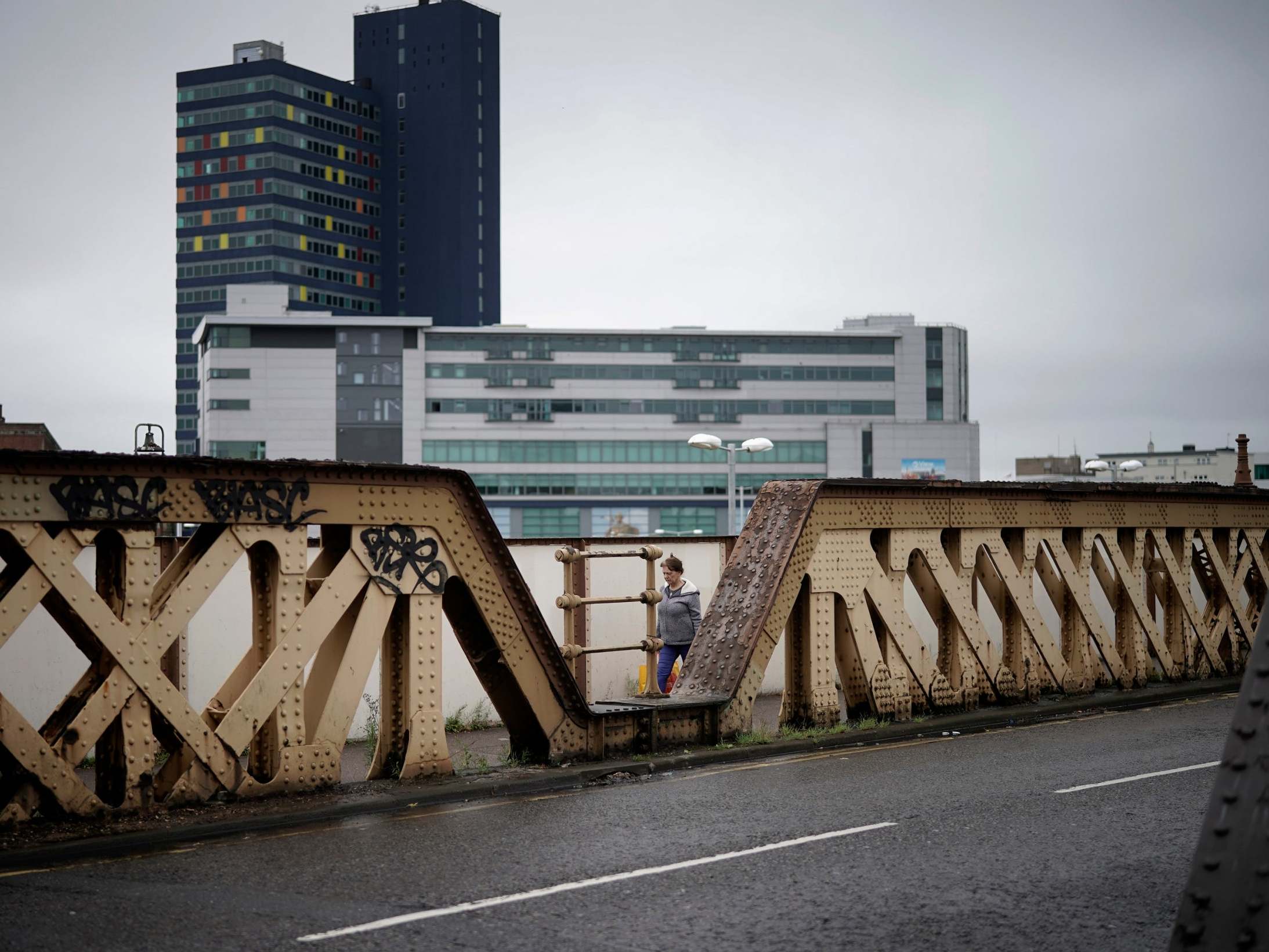 A woman walks across a railway bridge near the city centre during lockdown