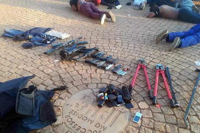 Arrested suspects and confiscated weapons are pictured at a church near Johannesburg after a siege on 11 July, 2020.