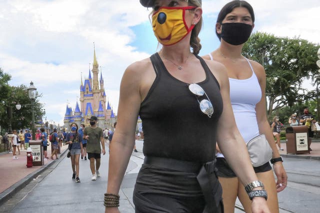 Guests wear masks as required to attend the official reopening day of the Magic Kingdom at Walt Disney World in Lake Buena Vista, Florida