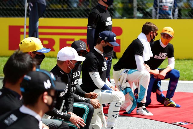 Max Verstappen stands while other F1 drivers take a knee ahead of the Styrian Grand Prix