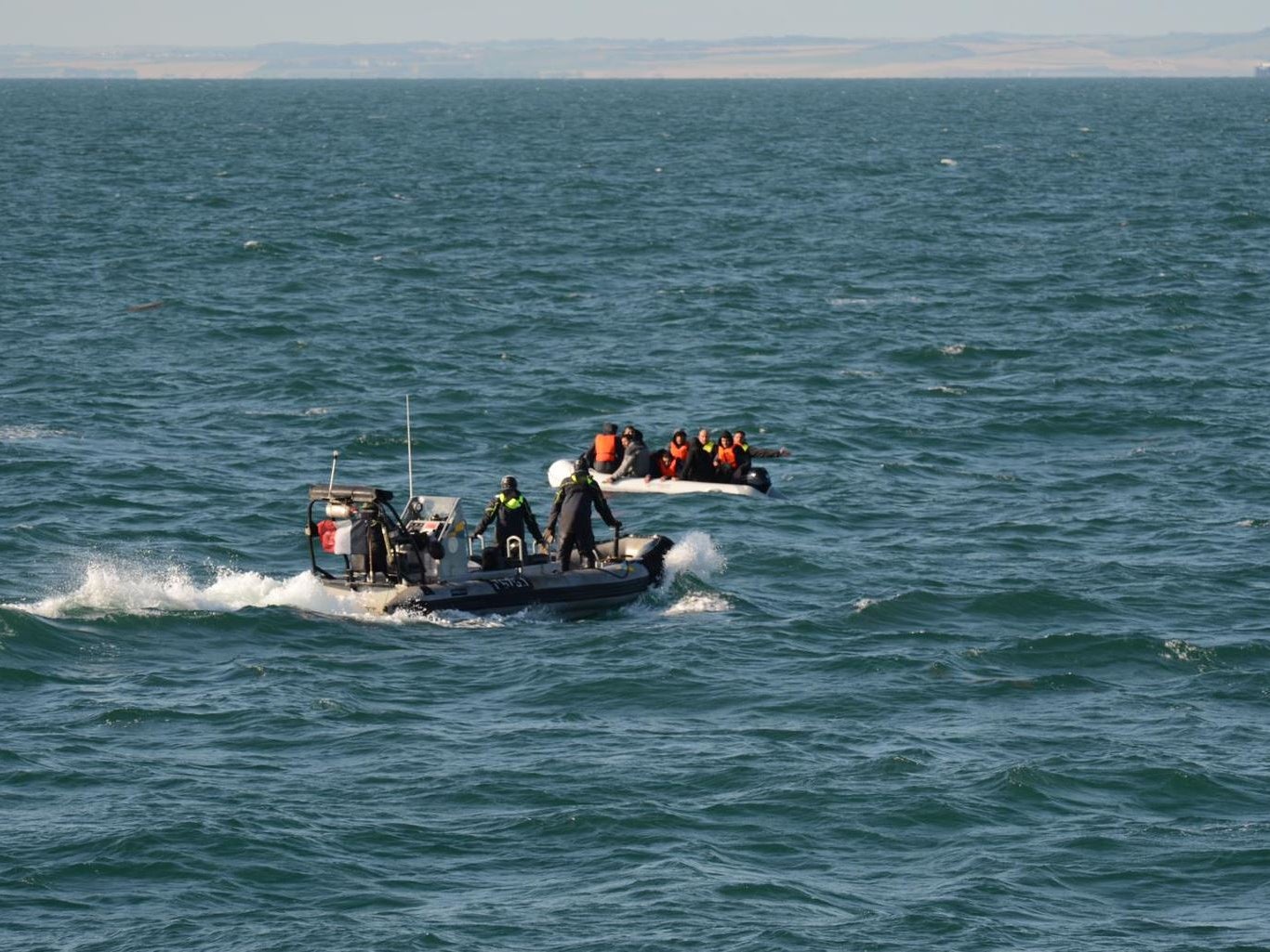 Rescuers reach a group of migrants in the English Channel on Saturday