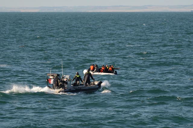 Rescuers reach a group of migrants in the English Channel on Saturday