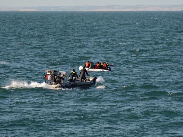 Rescuers reach a group of migrants in the English Channel on Saturday